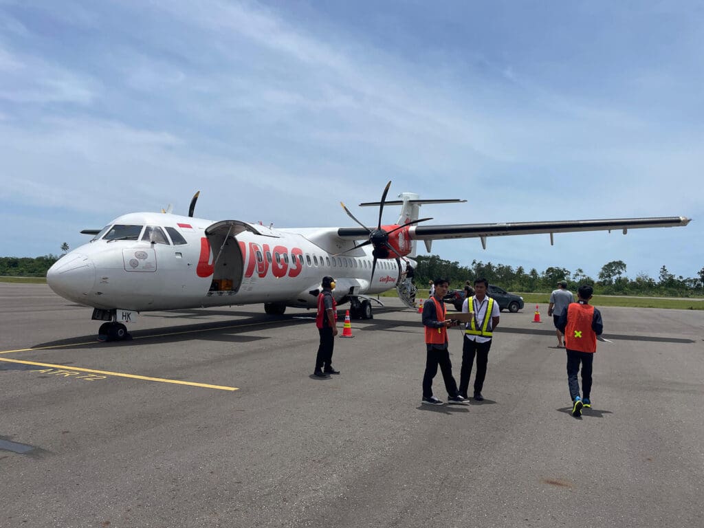 Wings Air ATR 72 aircraft on the runway at Rokot Airport, Mentawai with ground crew preparing for departure to Padang